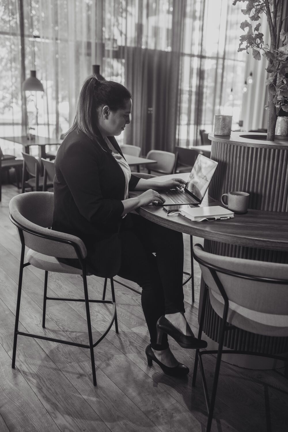Ylonka Kaupang sitter ved et kafébord og jobber på laptopen