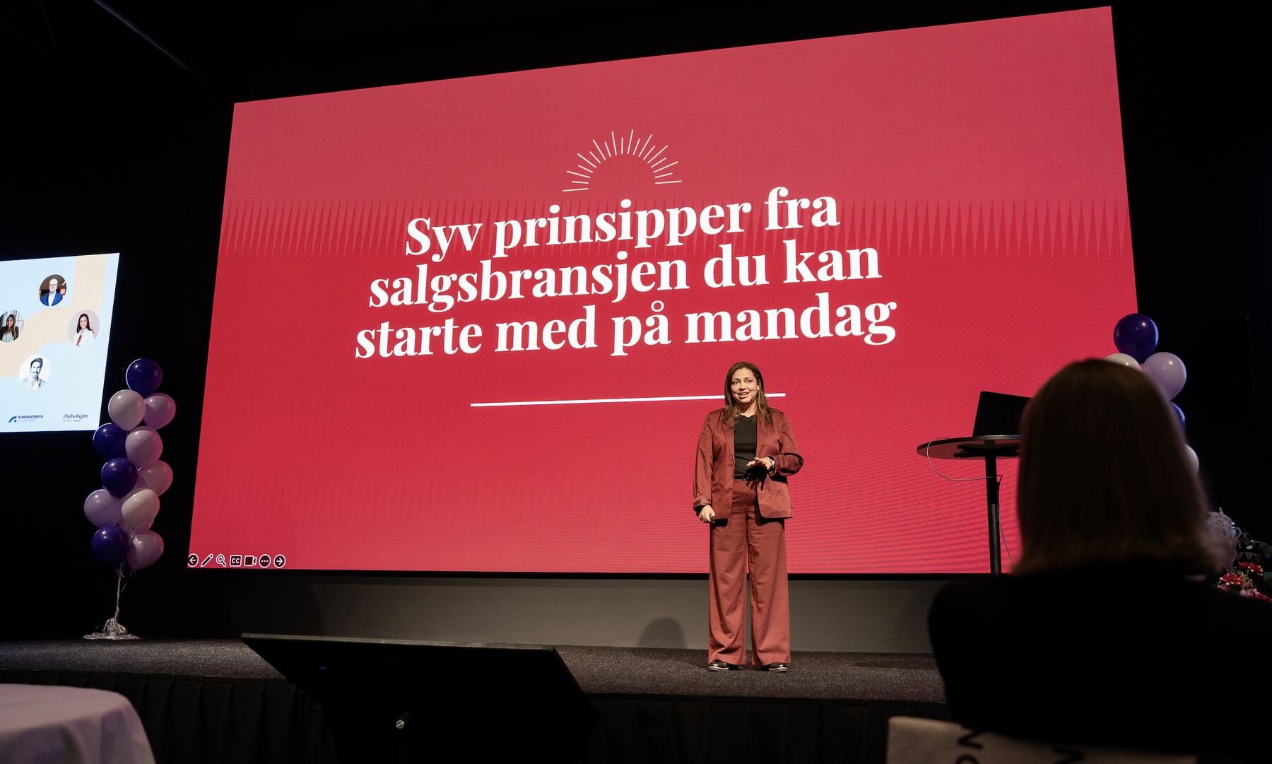 Ylonka Kaupang på scenen foran lysbildet «Syv prinsipper fra salgsbransjen du kan starte med på mandag»